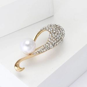 Elegante spilla in lega dorata con perla bianca e strass scintillanti su display bianco