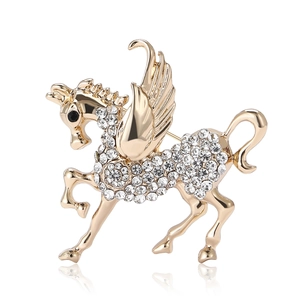 Sparkling gold Pegasus brooch with white rhinestones on a clean white background