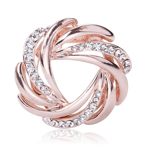Detailed view of rose gold round brooch featuring spiral patterns and white rhinestones