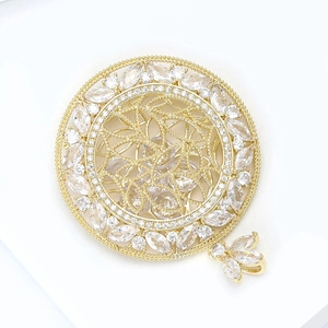 Broche disque évidé en or avec zircones cubiques marquise et pendentif papillon