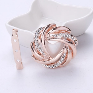 Detailed macro of rose gold floral spiral brooch with sparkling inlaid rhinestones