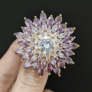 Vue macro d'une broche tournesol sertie de zircons et de pétales violets brillants