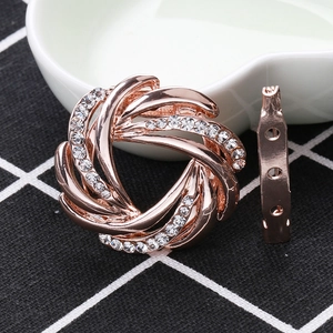 Detail view of rose gold spiral brooch with rhinestones and three-hole safety pin fastener