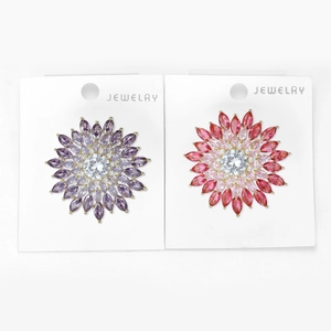 Vue détaillée de broches tournesol serties de zircons violets et rouges étincelants