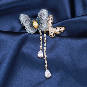 Gros plan sur broche papillon en tissu bleu avec pampilles serties de zircons