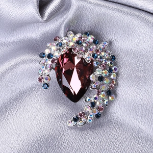 Detailed shot of a luxury brooch with red teardrop crystal and colorful rhinestones