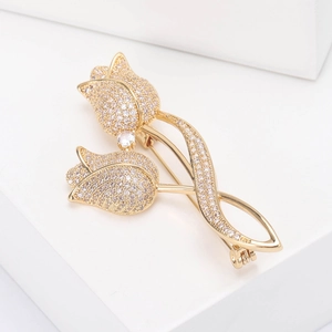 Detail of elegant gold tulip brooch featuring micro-set cubic zirconia on geometric stand