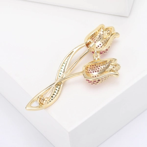 Detail view of golden tulip brooch with pink and green pavé cubic zirconia inlay