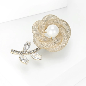 Élégante broche fleur en maille dorée avec perle blanche et accents de cristal