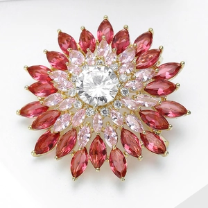 Vue macro d'une broche tournesol avec zircons micro-pave roses et rouge foncé