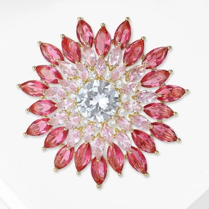 Détail d'une broche tournesol avec cristaux dégradés roses et pierre centrale en zircon