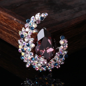 Luxury crystal brooch with a deep red teardrop gem and colorful rhinestones on silver base