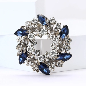 Macro d'une broche couronne dorée rétro avec gemmes bleu marine et strass brillants