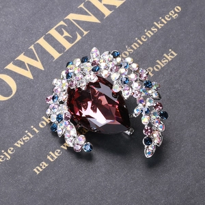 Macro shot of luxury vintage brooch with red pear-shaped stone and colorful rhinestones