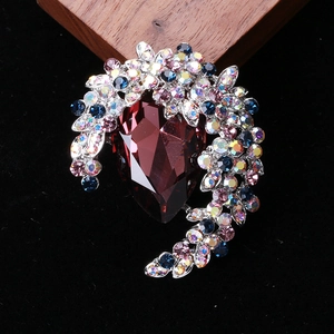 Detailed close-up of retro floral brooch with red teardrop crystal and colorful rhinestones