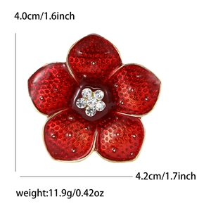 Broche fleur de pavot en émail rouge avec centre en cristal et bordure dorée sur fond blanc