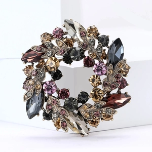 Détail d'une broche couronne vintage en alliage avec des strass colorés facettés