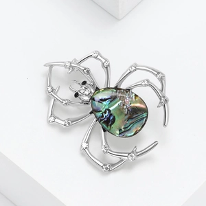 Vintage spider brooch with abalone shell and sparkling crystals on a minimalist stand