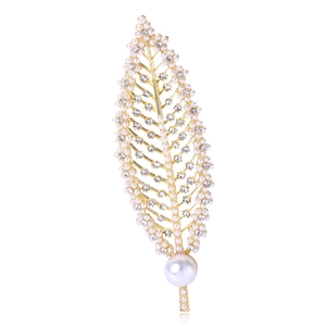 Close-up of golden leaf brooch with fine white imitation pearls and sparkling zircons