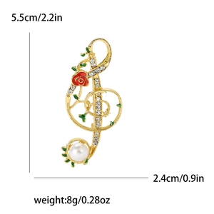 Broche clé de sol dorée avec rose rouge, strass brillants et perle élégante
