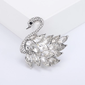 Sparkling silver swan brooch with marquise-cut crystals on a white pedestal