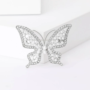 Vue détaillée d'une broche papillon en métal argenté ornée de perles et de strass
