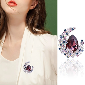 Elegant crescent moon brooch with purple teardrop crystal on white suit lapel