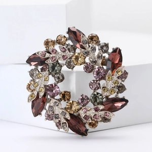 Détail de la broche couronne avec strass colorés sur un bloc d'affichage blanc