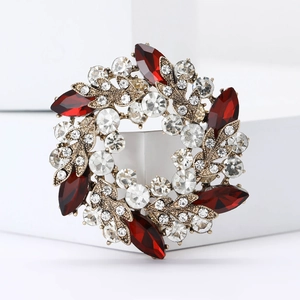 Détail d'une broche florale élégante avec pierres rouges marquises et cristaux clairs