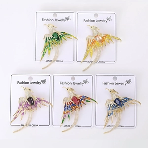 Detail of luxury phoenix brooches featuring colorful enamel wings and zircon stones