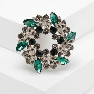 Broche couronne de fleurs bauhinia argentée avec strass verts et gris fumé élégante