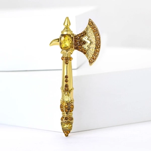 Close-up of alloy axe brooch with sparkling yellow rhinestones on a gold base