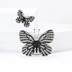 Elegant butterfly brooch set with white crystals and black accents on stone blocks