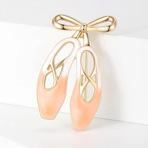 Broche ballerine élégante en métal doré et émail dégradé rose sur socle blanc