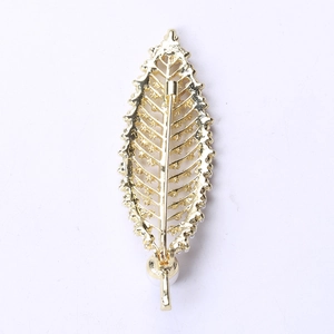 Detail of a golden leaf brooch with hollow veins and a delicate white pearl accent