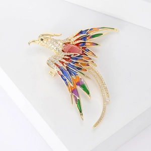 Detailed macro shot of phoenix brooch with colorful enamel wings and sparkling zircon