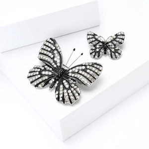 Creative butterfly brooch set with white and black crystals on a silver metal base
