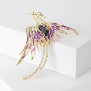 Macro view of phoenix brooch featuring purple enamel wings and white zircon stones