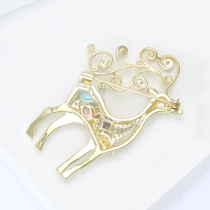 Broche renne dorée élégante avec pierres précieuses colorées sur fond blanc épuré