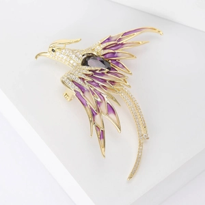 Detail of phoenix brooch with purple enamel wings and zircon stones on white display