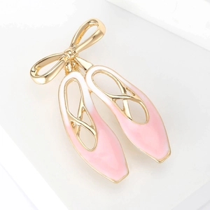 Broche créative en forme de chausson de danse rose avec nœud doré sur fond blanc