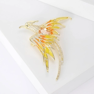 Detailed close-up of a phoenix brooch with gold plating, zircons, and gradient enamel
