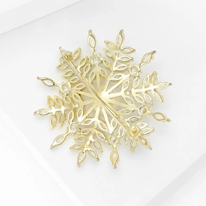 Vue détaillée de l'arrière d'une broche flocon dorée avec fermoir de sécurité en métal