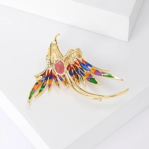 Luxurious phoenix brooch with colorful enamel wings and golden metal base shown from back view