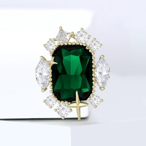 Vintage gold cocktail ring featuring a large emerald-cut green stone and zircon star accents
