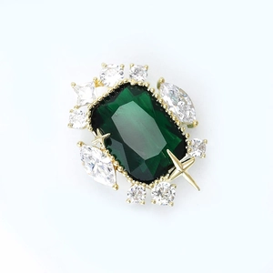 Vintage gold brooch with emerald cut green crystal and star accent stones