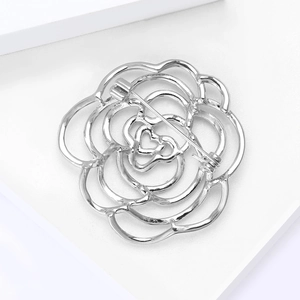 Makrodetail der silbernen hohlen Kamelienbrosche mit elegantem Blütenblattdesign und Nadel