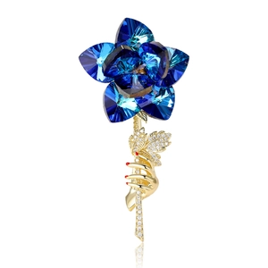 Broche fleur de rose en cristal bleu avec tige main dorée et zircons étincelants