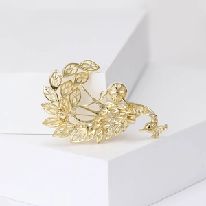 Luxury gold peacock brooch with intricate hollow feathers and sparkling white crystals