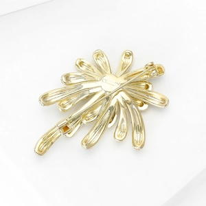 Detailed back view of the gold flower brooch showing the secure safety pin clasp mechanism